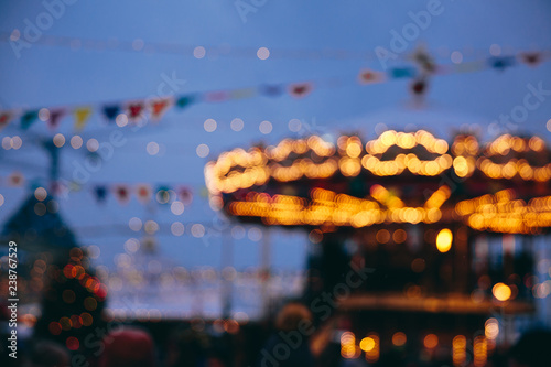 Fototapeta Naklejka Na Ścianę i Meble -  Blurred attraction with yellow lights on blue sky background. New year evening