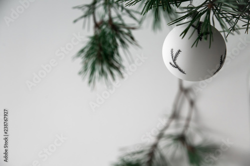 Christmas black and white toy among fir branches