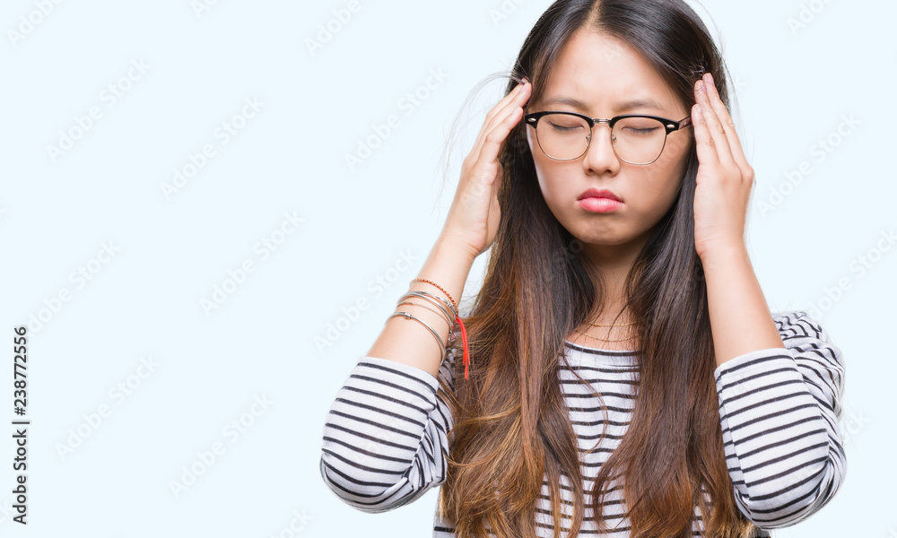 Young asian woman wearing glasses over isolated background with hand on head for pain in head because stress. Suffering migraine. Young asian woman wearing glasses over isolated background with hand on head for pain in head because stress. Suffering migraine.