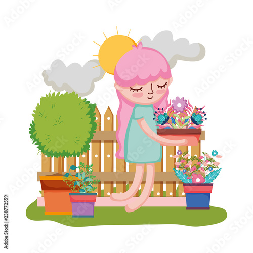 girl lifting houseplant with fence in the garden