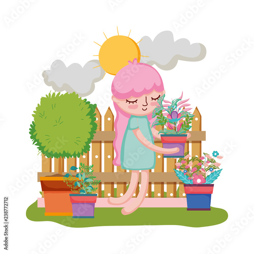 girl lifting houseplant with fence in the garden