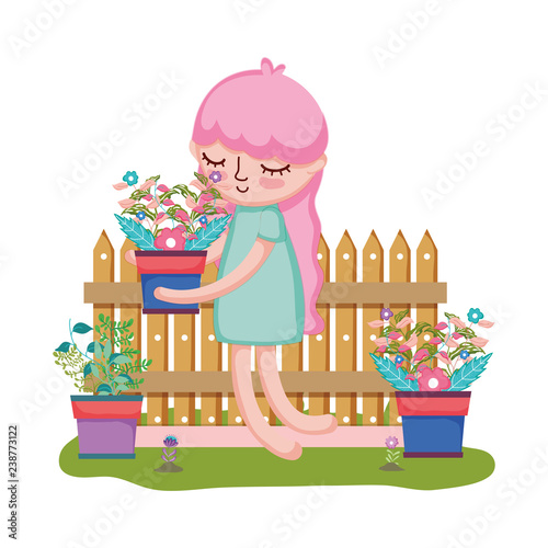 girl lifting houseplant with fence in the garden
