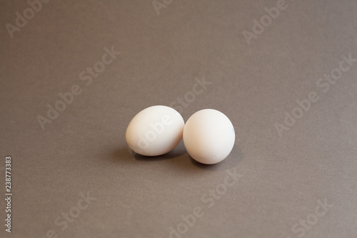 two white eggs on grey background