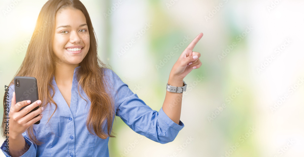 Young beautiful brunette business woman using smartphone over isolated background very happy pointing with hand and finger to the side Young beautiful brunette business woman using smartphone over isolated background very happy pointing with hand and finger to the side