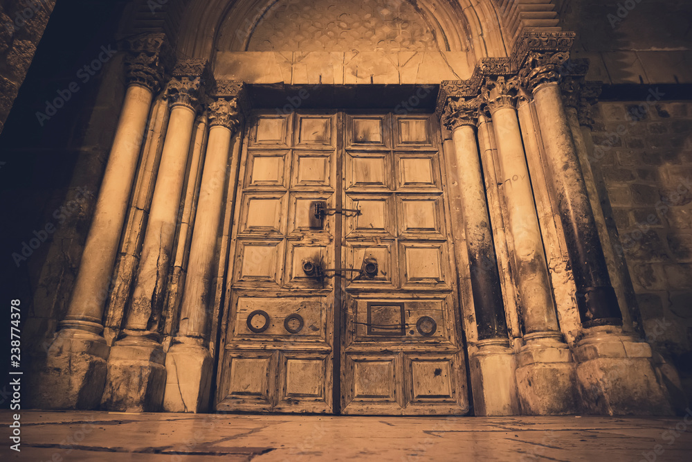 Fototapeta premium Old wooden door of entrance to the Church of the Holy Sepulchre, also called the Church of the Resurrection or Church of the Anastasis, in Old City of Jerusalem.