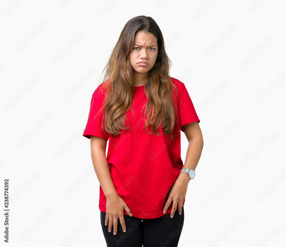 Young beautiful brunette woman wearing red t-shirt over isolated background skeptic and nervous, frowning upset because of problem. Negative person. Young beautiful brunette woman wearing red t-shirt over isolated background skeptic and nervous, frowning upset because of problem. Negative person.