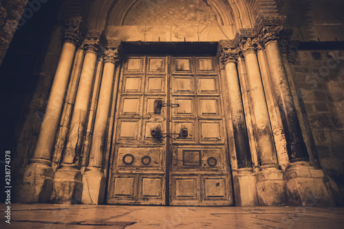 Old wooden door of entrance to the Church of the Holy Sepulchre, also called the Church of the Resurrection or Church of the Anastasis, in Old City of Jerusalem. photo