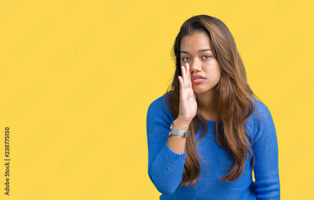 Young beautiful brunette woman wearing blue sweater over isolated background hand on mouth telling secret rumor, whispering malicious talk conversation