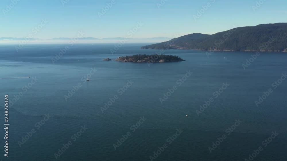 Aerial view over Burrard Inlet, ocean and island with boat and mountains in beautiful British Columbia. Canada. Aerial view over Burrard Inlet, ocean and island with boat and mountains in beautiful British Columbia. Canada.