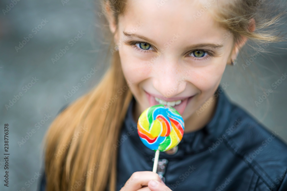 Beautiful little girl with candy, outdoor