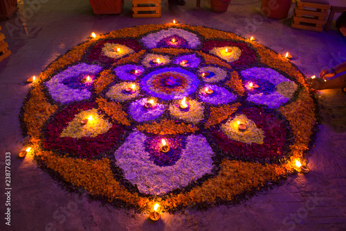 Mandala of flowers with burning candles at night.