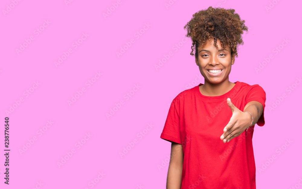 Beautiful young african american woman over isolated background smiling friendly offering handshake as greeting and welcoming. Successful business. Beautiful young african american woman over isolated background smiling friendly offering handshake as greeting and welcoming. Successful business.