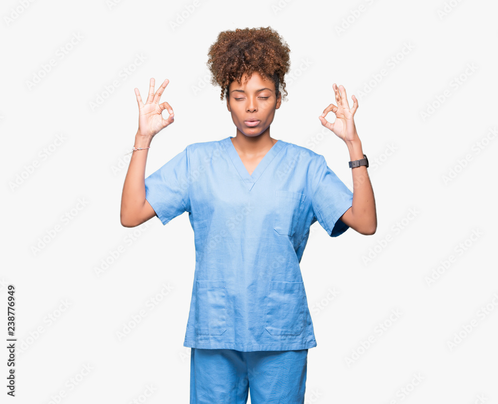 Young african american doctor woman over isolated background relax and smiling with eyes closed doing meditation gesture with fingers. Yoga concept. Young african american doctor woman over isolated background relax and smiling with eyes closed doing meditation gesture with fingers. Yoga concept.