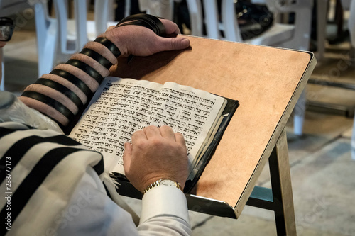 Religion Jew reading prayer book. Torah on the table in front of the wailing wall in the old city of Jerusalem Israel. photo