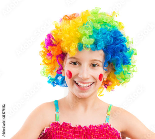 Funny little girl in clown wig with red spots on her cheeks isolated on white background