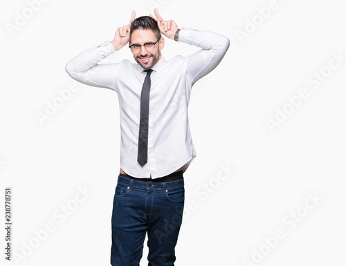 Young handsome business man wearing glasses over isolated background Posing funny and crazy with fingers on head as bunny ears, smiling cheerful