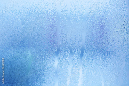 Misted glass background. Strong humidity in wintertime. Water drops from home condensation on a window photo