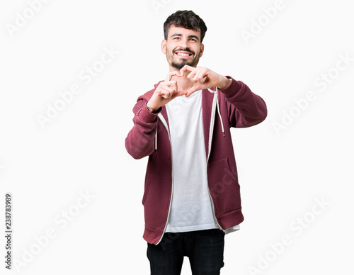 Young handsome man over isolated background smiling in love showing heart symbol and shape with hands. Romantic concept.