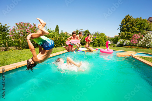 Carta da parati Group of happy teens having fun in swimming pool