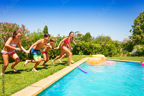 Happy teens running together to swimming pool © Sergey Novikov