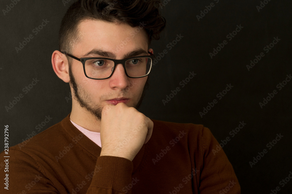 Hipster young man in glasses and woolen sweater on a black background. Hipster young man in glasses and woolen sweater on a black background.