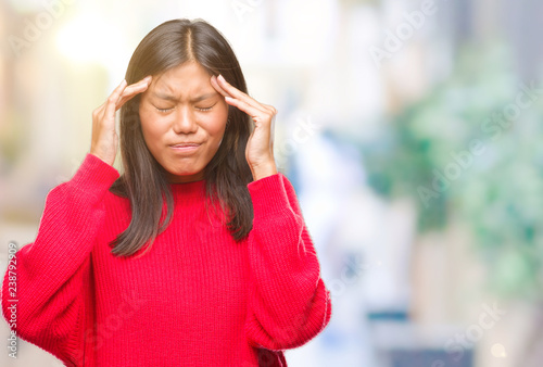 Young asian woman wearing winter sweater over isolated background with hand on head for pain in head because stress. Suffering migraine.