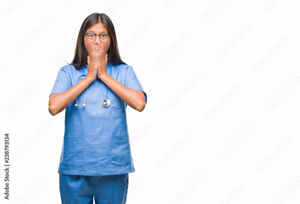 Young asian doctor woman over isolated background shocked covering mouth with hands for mistake. Secret concept.