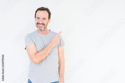 Handsome senior man over isolated background cheerful with a smile of face pointing with hand and finger up to the side with happy and natural expression on face