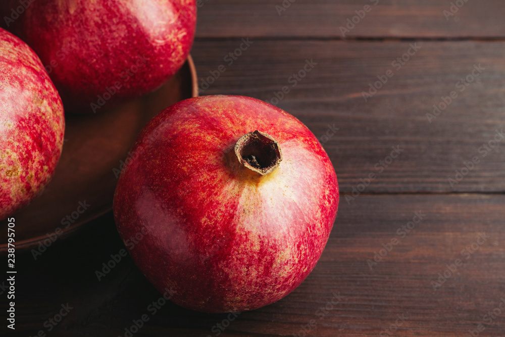 Group of pomegranate red fruits on the dark wooden background Group of pomegranate red fruits on the dark wooden background