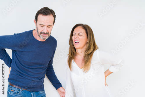 Beautiful middle age couple in love over isolated background Suffering of backache, touching back with hand, muscular pain