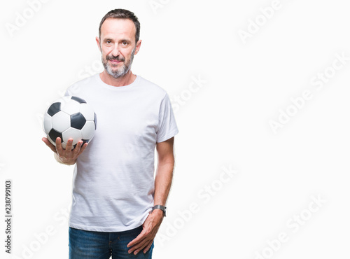 Middle age hoary senior man holding soccer football ball over isolated background with a confident expression on smart face thinking serious