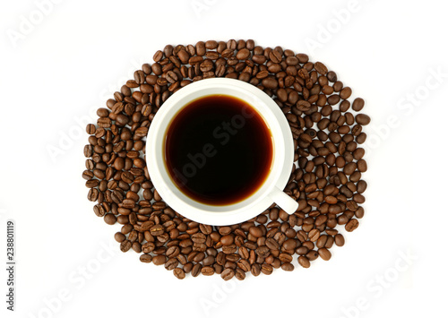 Black coffee in a white cup on the pile of roasted coffee beans isolated on white background 