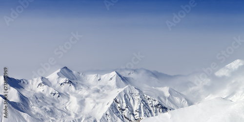 Panoramic view on snowy sunlight mountains in haze © BSANI