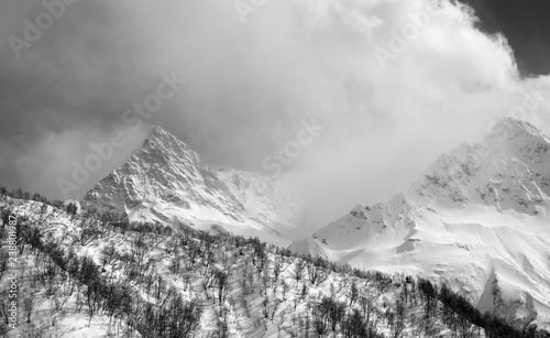 High mountain peaks in fog and sunlight cloudy sky