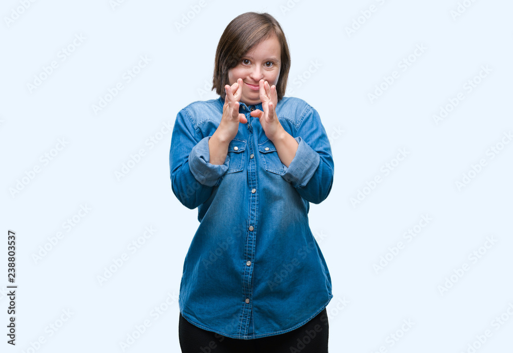 Young adult woman with down syndrome over isolated background smiling crossing fingers with hope and eyes closed. Luck and superstitious concept. Young adult woman with down syndrome over isolated background smiling crossing fingers with hope and eyes closed. Luck and superstitious concept.