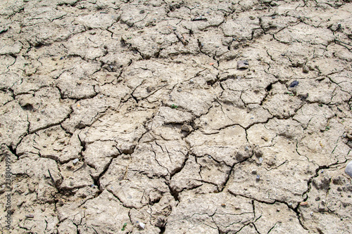 Dried and cracked earth soil from draught cracked terrain texture in summer from climate change and global warming effect photo