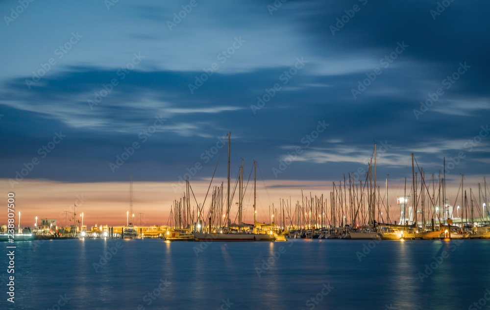 Yacht harbor of Cuxhaven Germany at sunset with water reflections.