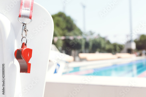 Coach whistle near swimming pool. Living coral theme - color of the year 2019