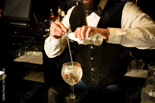 Young bartender preparing a delicious cocktail at the bar of a cocktail bar.