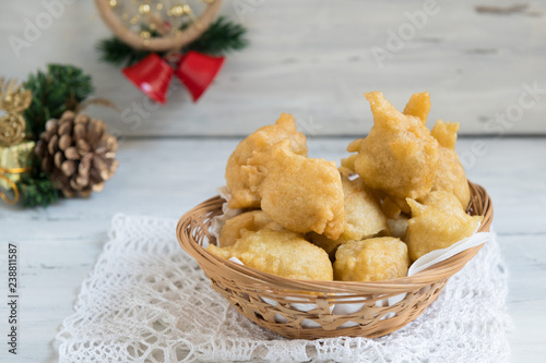 Tipical christmas Italian food called pettole on light wooden background with christmas decoration photo
