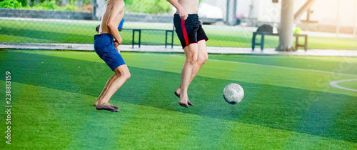 Fototapeta Naklejka Na Ścianę i Meble -  Soccer players not wearing a sport shirt and barefoot do trap and control the ball for shoot to goal