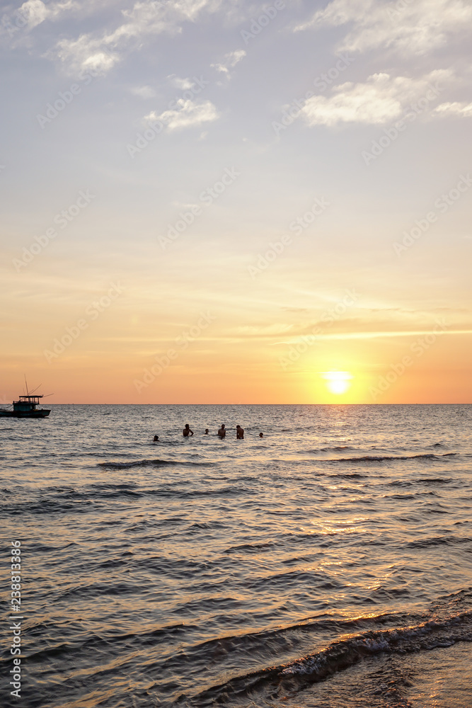 Local kids are playing in the water at sunset on Phu Quoc in Vietnam