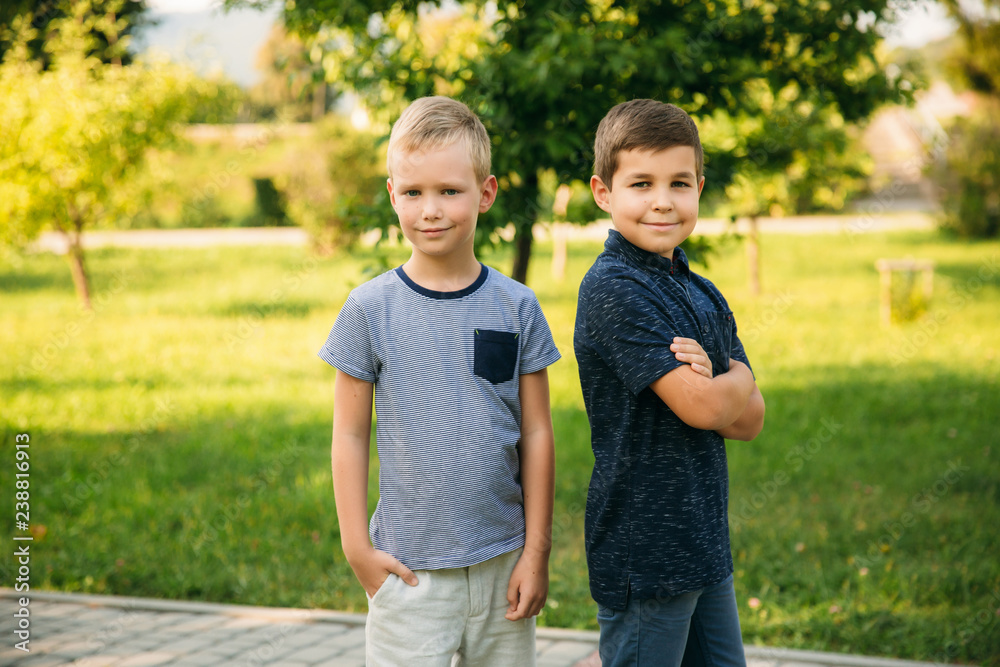 Fototapeta premium Two boys friends spend time in park. Children models