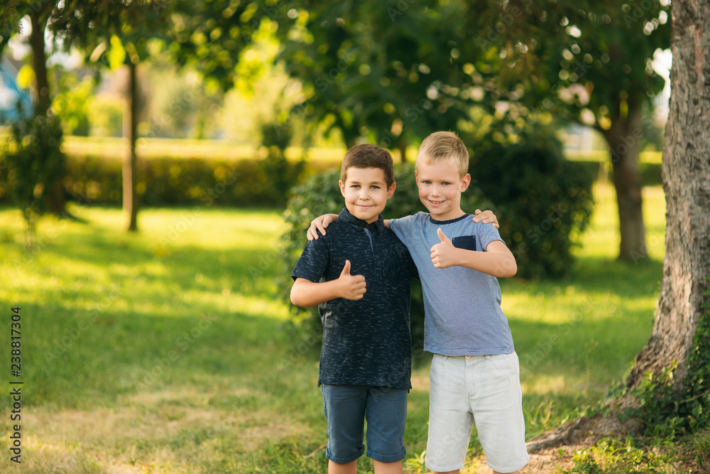 Obraz premium Two bothers spend time in park. They have fun and some relax befour school