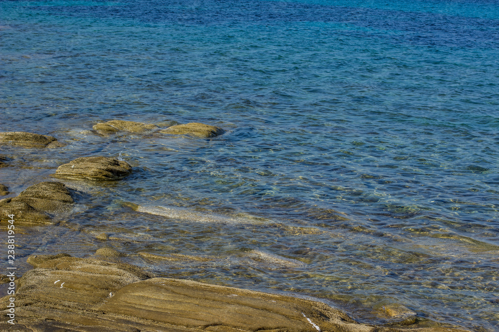 tropic sea rock beach place and vivid blue water surface wallpaper pattern with empty space for copy or your text tropic sea rock beach place and vivid blue water surface wallpaper pattern with empty space for copy or your text