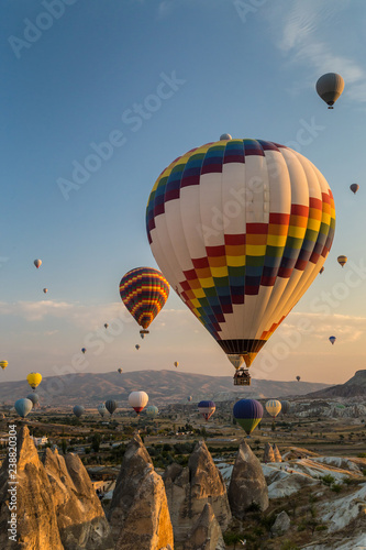 Hot air balloons flying at sunrise over rock formations in Cappadocia, Turkey