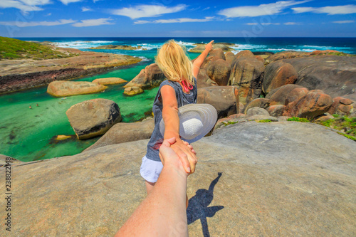 Follow me POV. Blonde woman holding hand of her friend at Elephant Rocks in Denmark, Western Australia. Girl enjoys of William Bay NP a popular Australian travel destination. Aerial view. photo