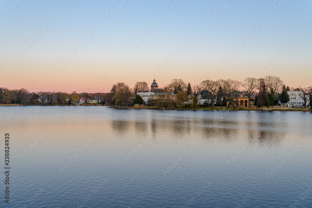 Scenery of Heiliger see, the lake in Potsdam, Germany and waterside in winter during sunset twilight time and sky.