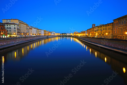 Night view of colorful medieval buildings on the quay reflecting on the Arno River in Pisa, Tuscany, Italy © eqroy