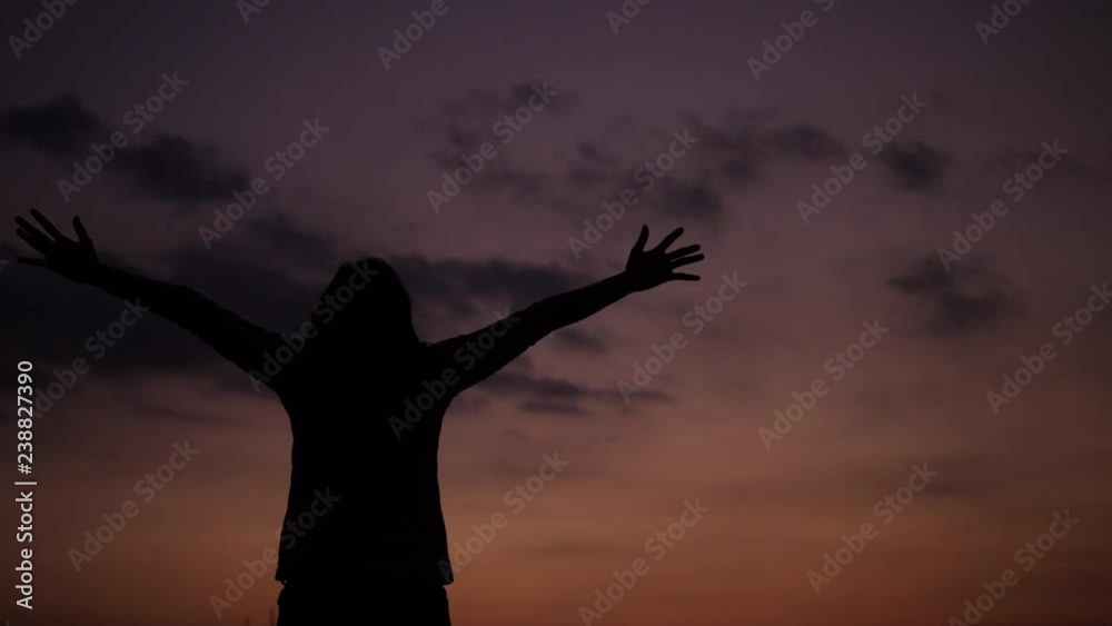 Woman with arms raised looking at sunset view. Woman with arms raised looking at sunset view.